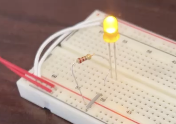 A photo of a powered yellow light in a breadboard.